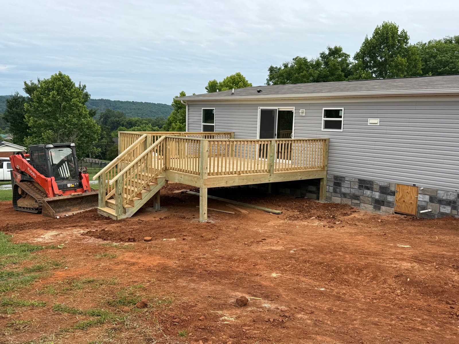 New wood deck under construction with skid steer