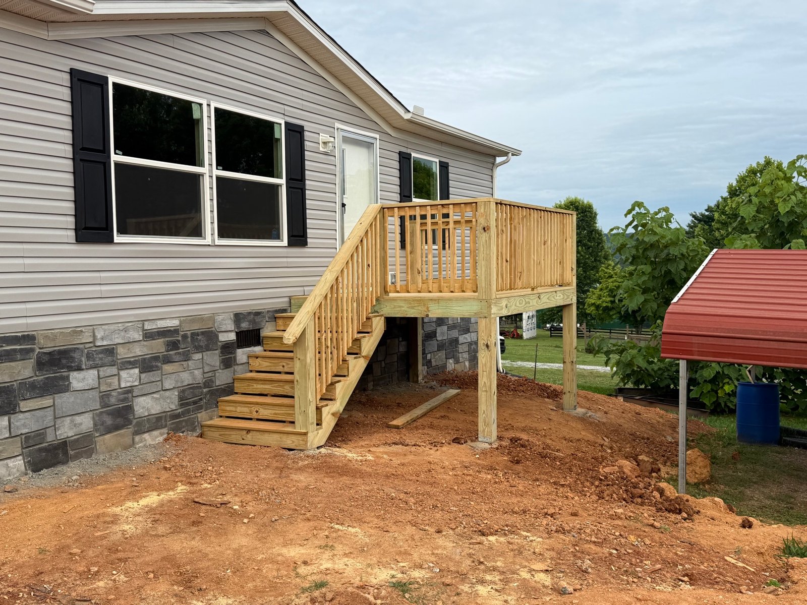 Raised deck with stairs beside a home