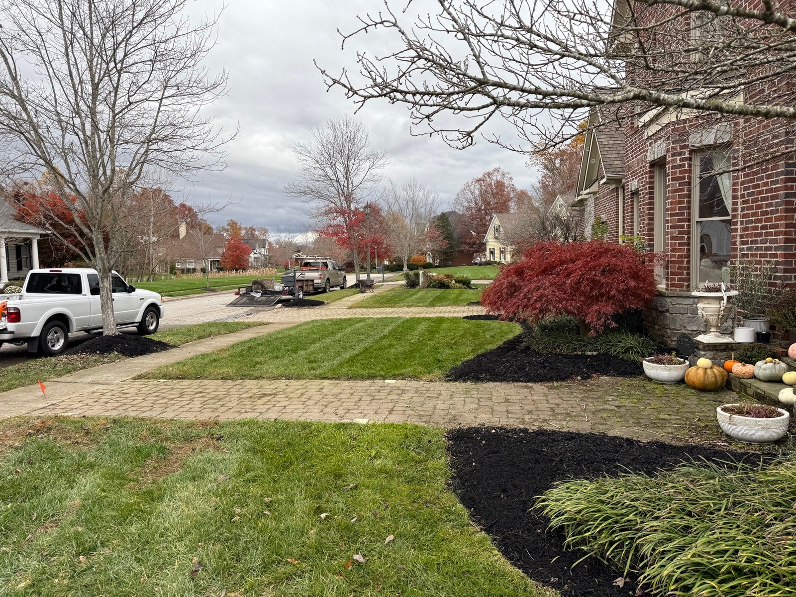 Front yard with fresh mulch beds and mow stripes, JSC truck on site